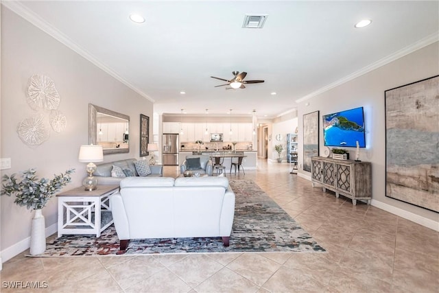 tiled living room with ornamental molding and ceiling fan