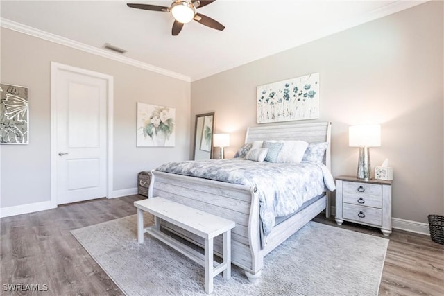 bedroom featuring hardwood / wood-style floors, crown molding, and ceiling fan