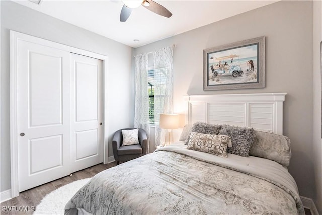 bedroom featuring hardwood / wood-style flooring, ceiling fan, and a closet