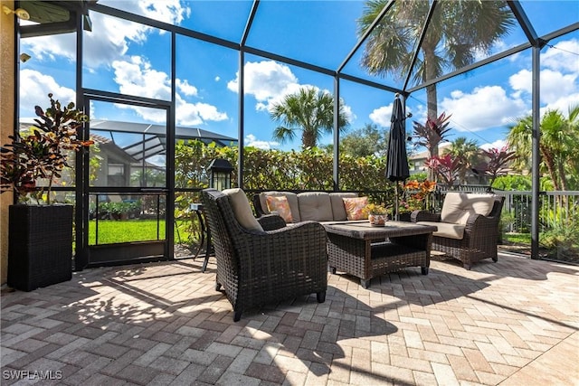 view of patio with an outdoor living space and glass enclosure