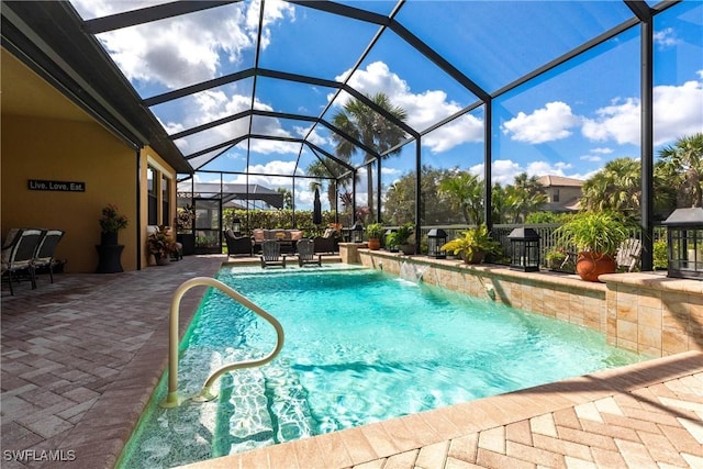 view of pool with a lanai, a patio area, and pool water feature