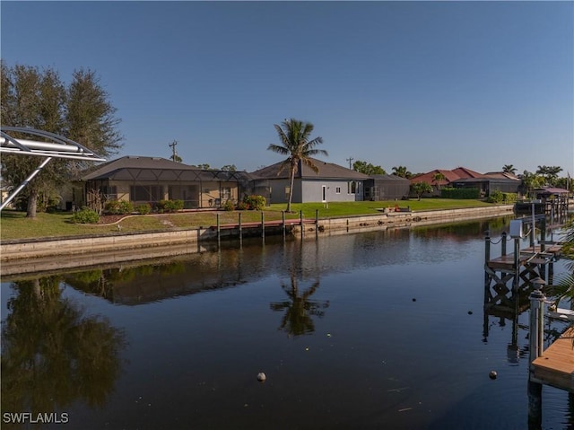 view of dock with a lawn, a water view, and a residential view