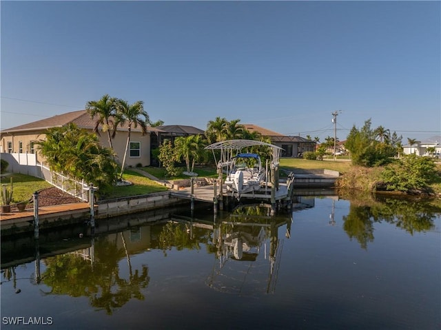 dock area featuring fence, a lawn, and a water view