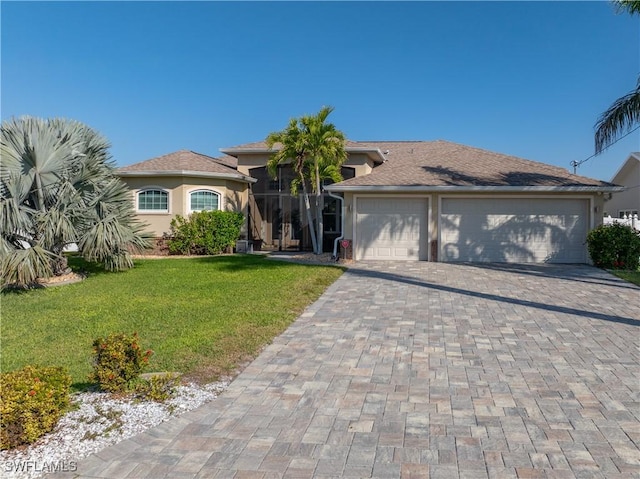 view of front of property featuring a front yard, decorative driveway, a garage, and stucco siding