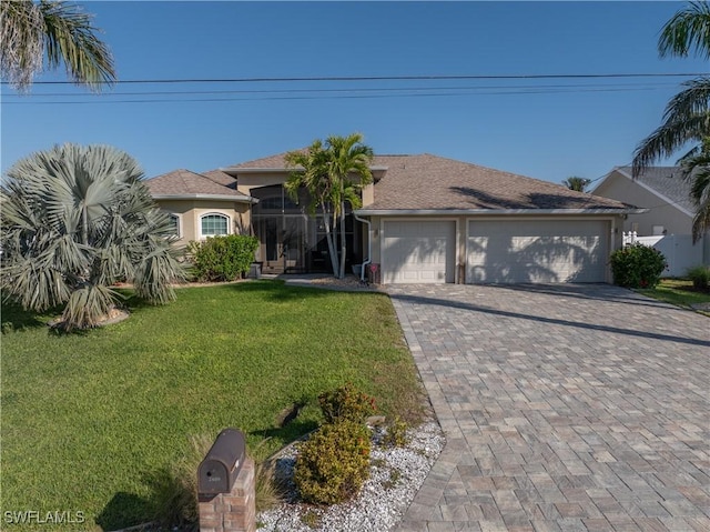 view of front of home featuring a front yard, decorative driveway, an attached garage, and stucco siding