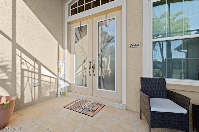 property entrance featuring stucco siding and french doors