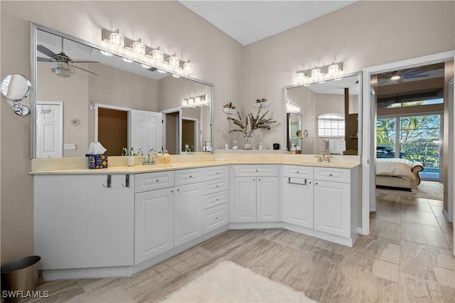 full bath with a sink, double vanity, ensuite bath, and a ceiling fan