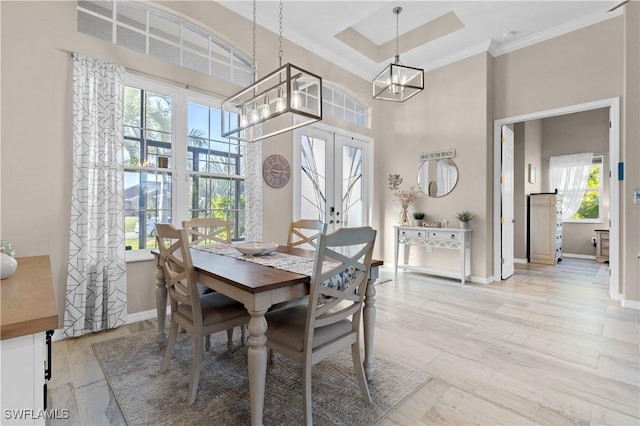 dining room with french doors, baseboards, a towering ceiling, and a chandelier