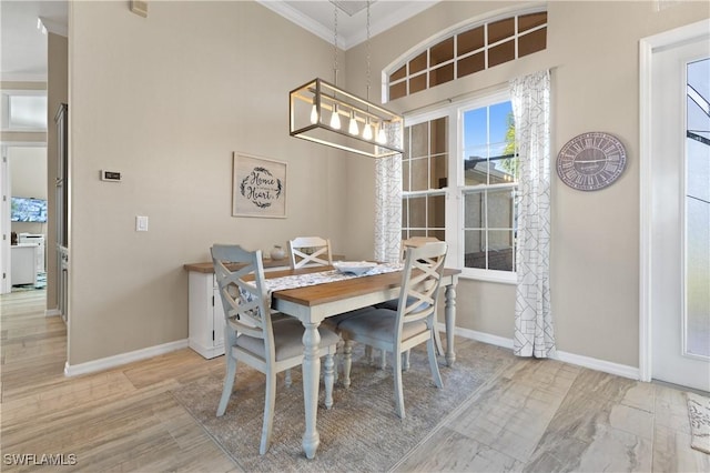 dining space with baseboards, a notable chandelier, wood finished floors, and crown molding