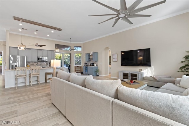 living area featuring ceiling fan, arched walkways, ornamental molding, and recessed lighting