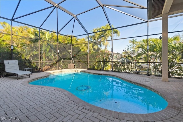 pool with glass enclosure and a patio