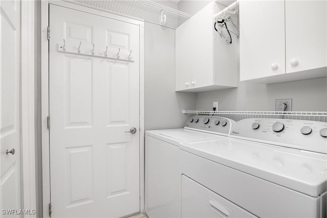 washroom featuring washer and clothes dryer and cabinets