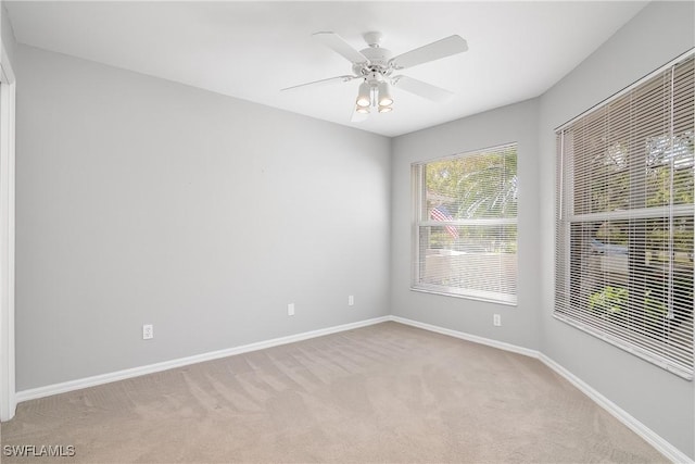 empty room featuring ceiling fan and light carpet