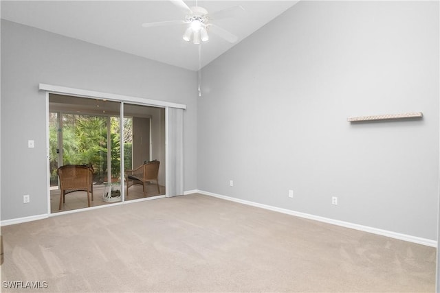 carpeted spare room featuring vaulted ceiling and ceiling fan