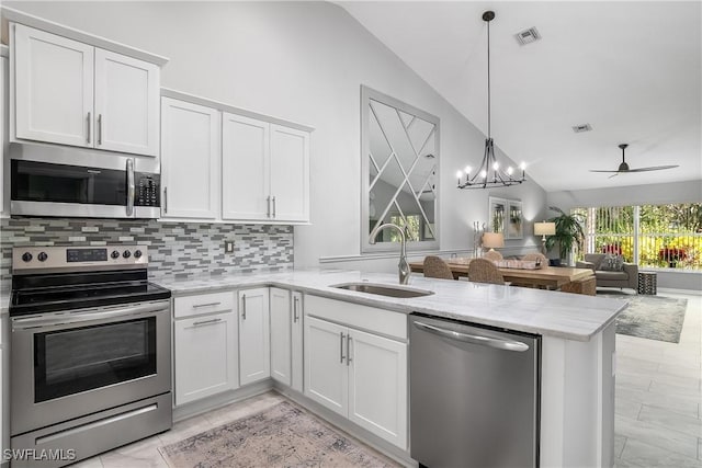 kitchen with sink, white cabinetry, decorative light fixtures, appliances with stainless steel finishes, and kitchen peninsula