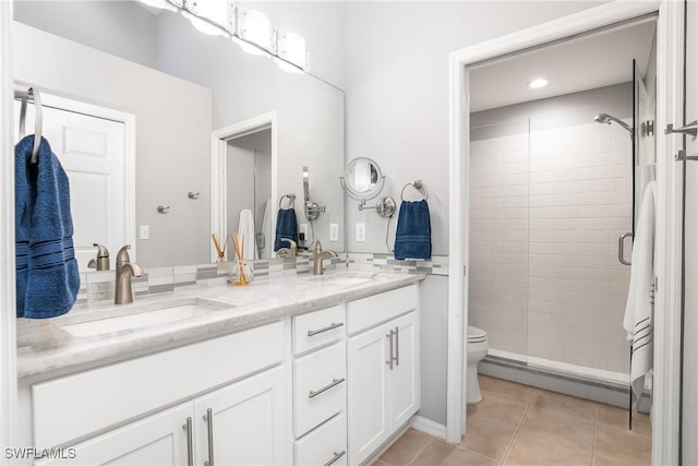 bathroom featuring tile patterned flooring, vanity, toilet, and an enclosed shower