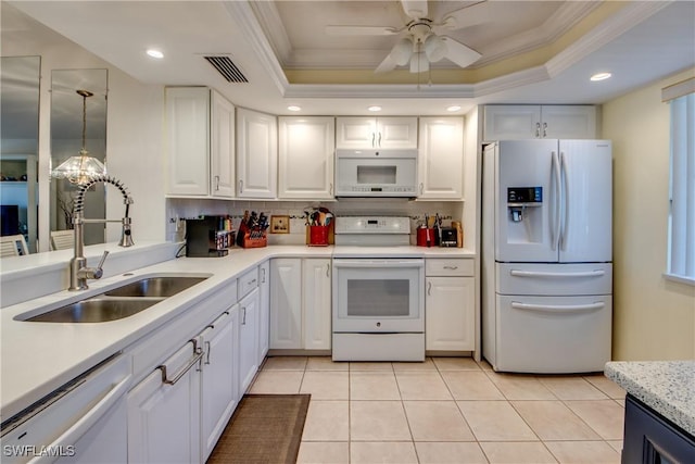 kitchen featuring white appliances, a raised ceiling, and white cabinets