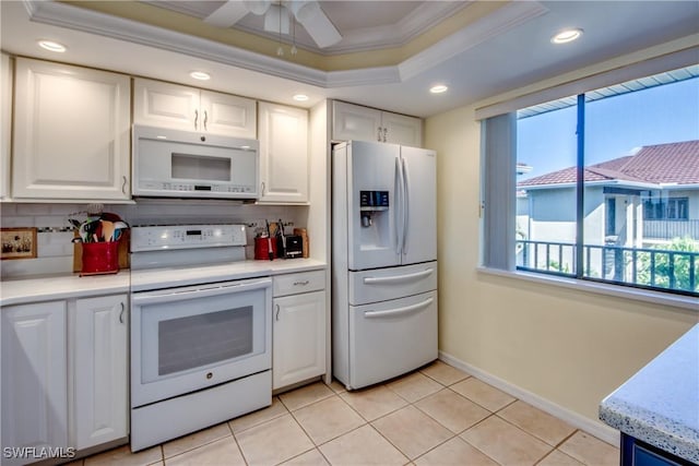 kitchen with a raised ceiling, white cabinetry, tasteful backsplash, and white appliances