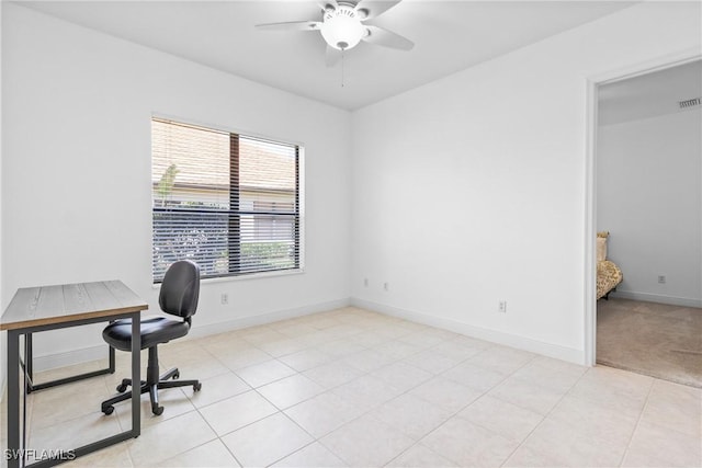 unfurnished office with visible vents, light tile patterned floors, a ceiling fan, and baseboards