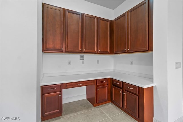 kitchen with light tile patterned flooring, light countertops, and built in study area