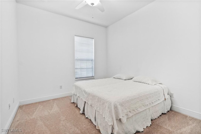 bedroom featuring a ceiling fan, light carpet, and baseboards