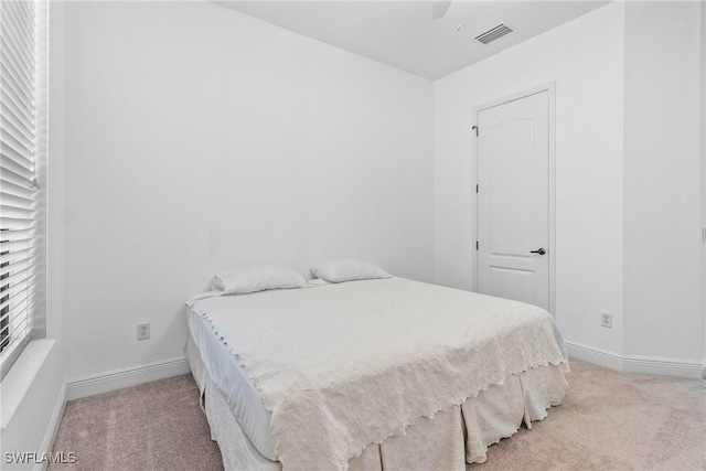 bedroom featuring light carpet, ceiling fan, visible vents, and baseboards