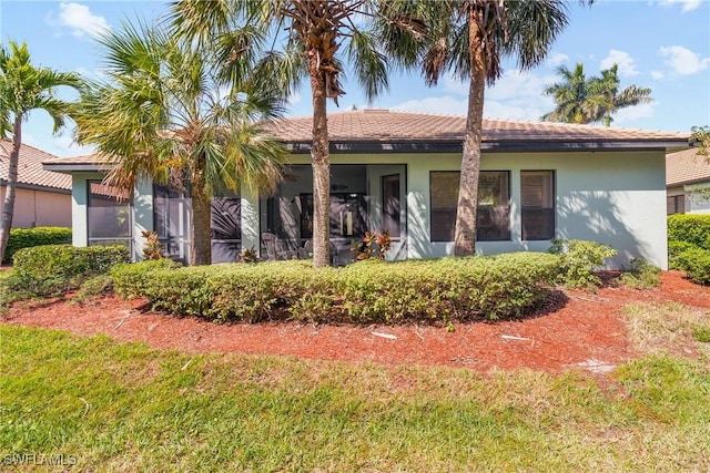 rear view of property with a lawn and stucco siding