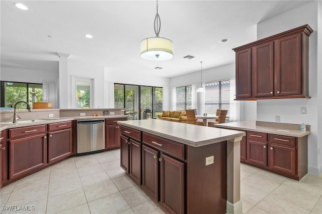 kitchen with hanging light fixtures, a sink, light countertops, and dishwasher