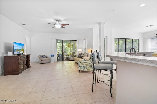 living area featuring visible vents, a ceiling fan, and light tile patterned flooring