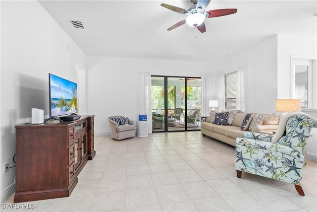 living room with light tile patterned floors, ceiling fan, visible vents, and baseboards