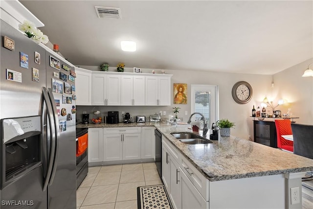 kitchen featuring sink, white cabinetry, light tile patterned floors, appliances with stainless steel finishes, and light stone countertops