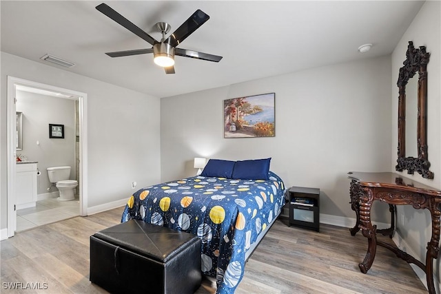 bedroom featuring ceiling fan, ensuite bath, and wood-type flooring