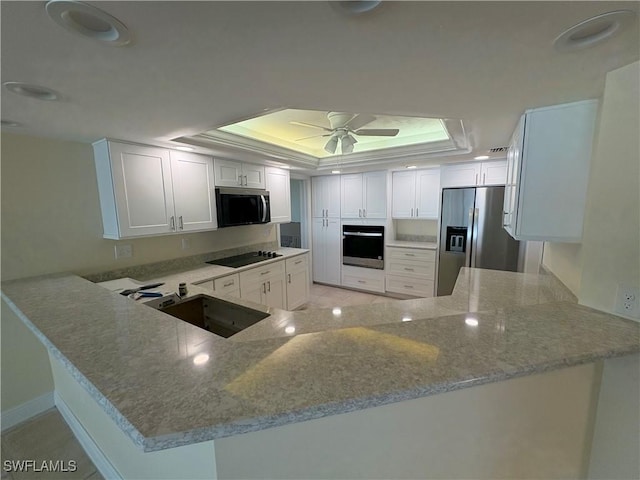 kitchen with sink, white cabinetry, stainless steel appliances, a raised ceiling, and kitchen peninsula