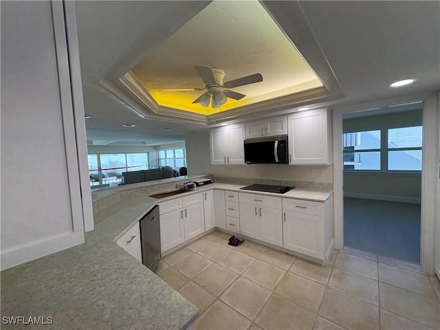 kitchen featuring a raised ceiling, white cabinetry, light tile patterned floors, kitchen peninsula, and stainless steel appliances