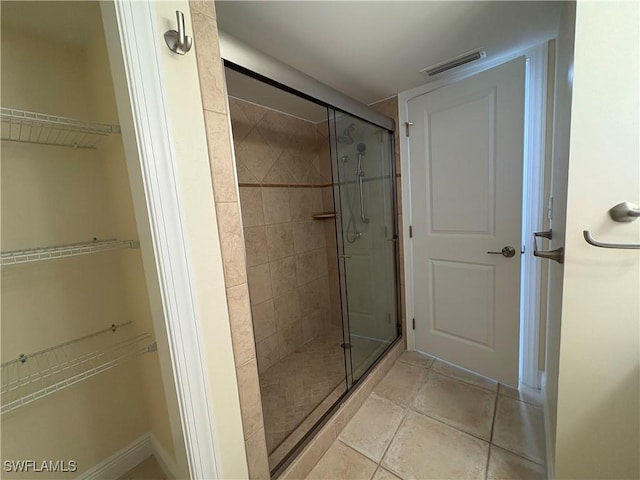 bathroom featuring a shower with door and tile patterned flooring