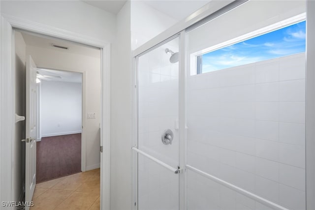 bathroom with a shower with door and tile patterned floors