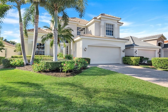 mediterranean / spanish house featuring a garage and a front lawn