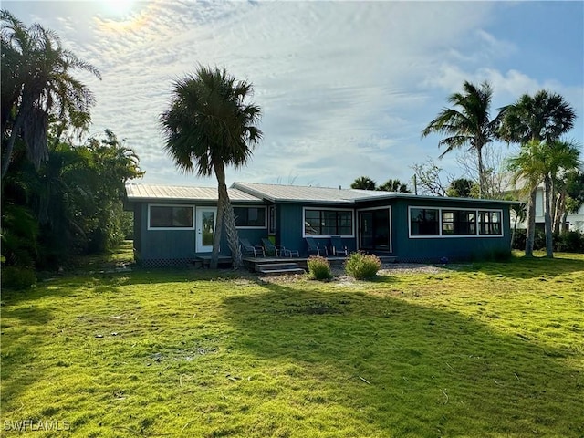 rear view of property with a yard