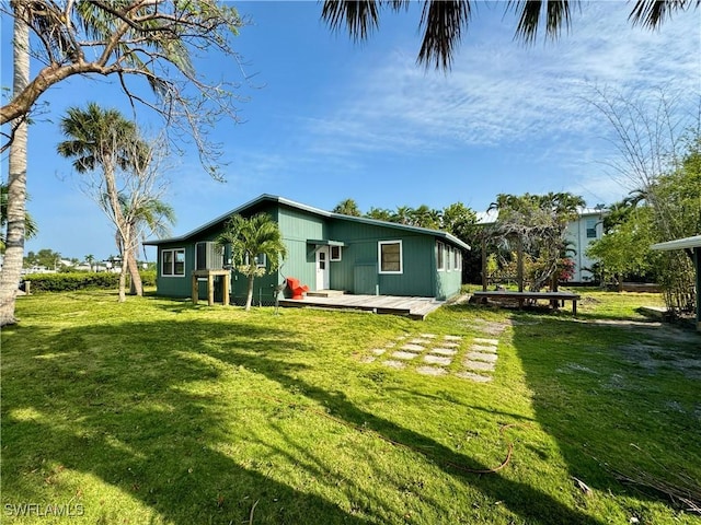 back of house featuring a yard and a deck