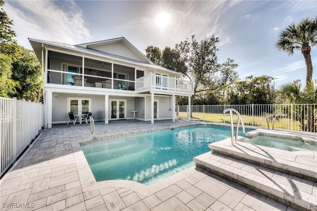 view of pool with a patio area, french doors, and an in ground hot tub