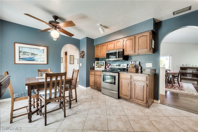 kitchen with appliances with stainless steel finishes, light tile patterned floors, and ceiling fan