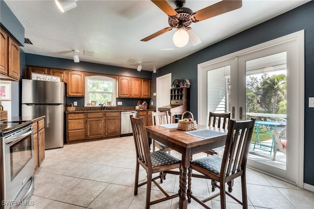 tiled dining room with sink, ceiling fan, and french doors