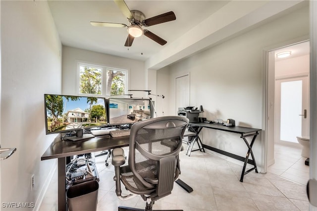 tiled home office featuring ceiling fan