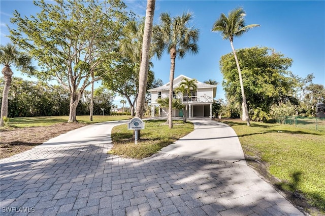 view of front of house featuring a garage, a balcony, and a front yard