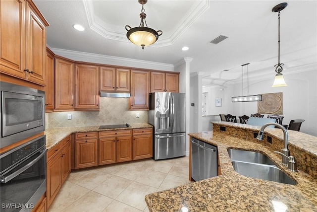 kitchen with appliances with stainless steel finishes, sink, and light stone counters