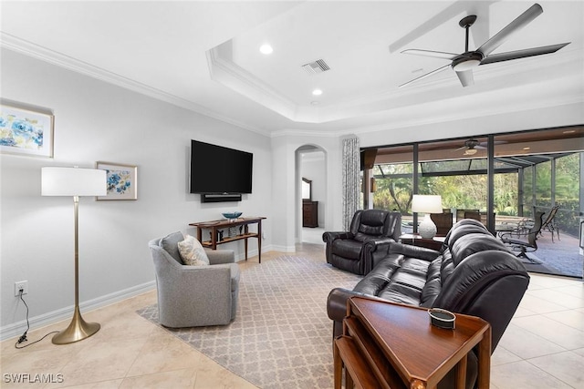 living room featuring crown molding, ceiling fan, a tray ceiling, and light tile patterned floors