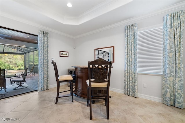 dining space featuring crown molding, light tile patterned floors, and a tray ceiling