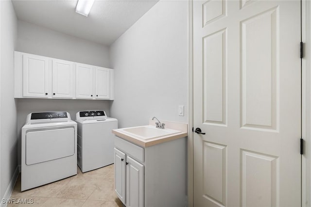 clothes washing area with cabinets, independent washer and dryer, light tile patterned flooring, and sink