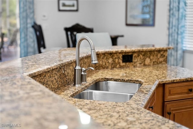 kitchen featuring light stone counters and sink