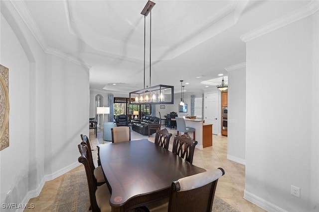 dining space with crown molding, a raised ceiling, and light tile patterned floors